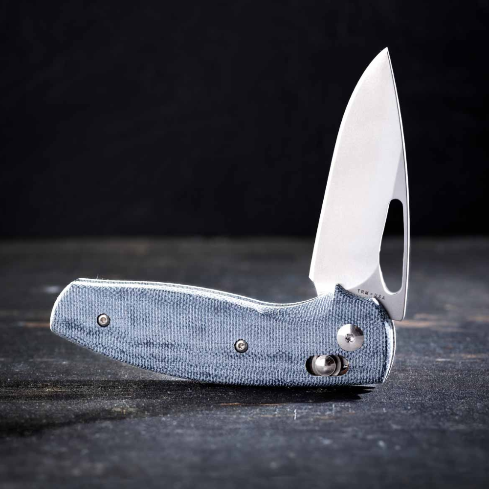 TRM Bulldog Rev B knife on a wood table with dark background