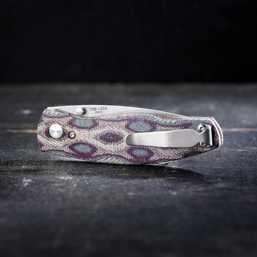 Neutron 2 Linerlock Python Micarta 3D Contoured Smooth knife closed on a wood table with dark background